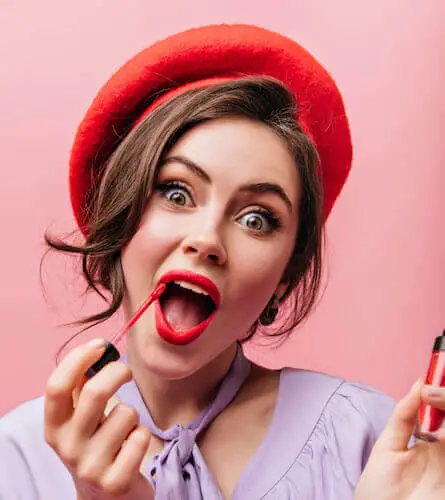 closeup portrait cheerful green eyed girl painting lips with red lipstick isolated background 1